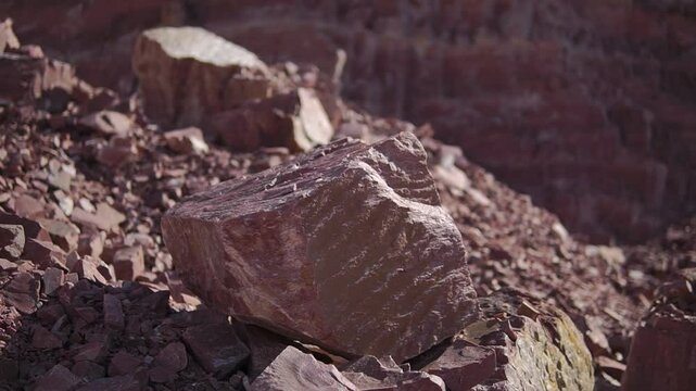 Quartzite rock close-up on pile of smaller stones in a quarry on sunny day
