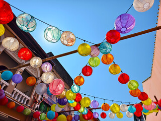 Multicolored Chinese lanterns hanging above the street.