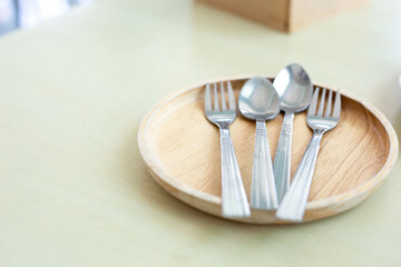 Spoon, fork and dish on wooden table in restaurant. Soft picture