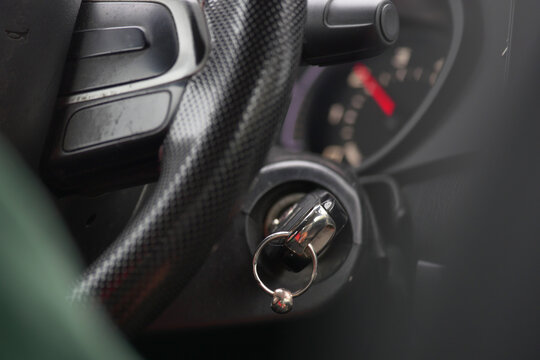 Close-up of car ignition and steering wheel at a roadside stop - Powered by Adobe