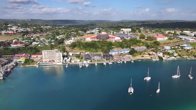Yachts On Waterfront Of Port Vila In Vanuatu With National Convention Center In View. aerial shot