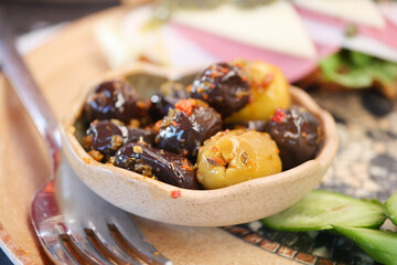 Colorful plate of marinated olives with spices on a dining table