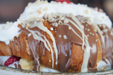 Delicious dessert with croissant, chocolate sauce, and fresh fruit