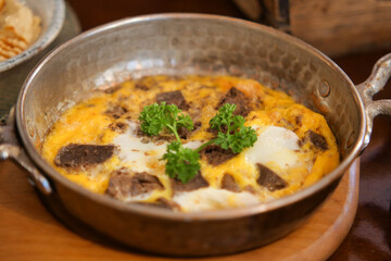 Delicious omelette with meat and herbs freshly cooked in a pan