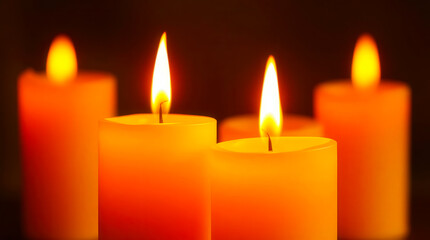 a group of lit candles on a dark background with warm lighting effects close up detail view natural
