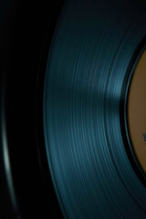 a close up view of a blue vinyl record on a dark background with studio lighting and natural shadows