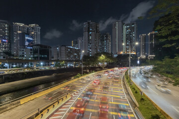 Obraz premium Car rushing by on the busy urban road in the city center of Kuala Lumpur at night