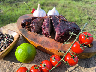 juicy steak on a chopping board surrounded by vegetables and fruits. High quality photo