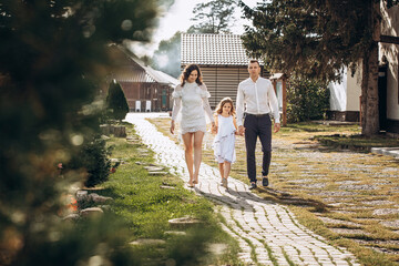 Family mother, father and daughter are beautiful and happy together, in white clothes, on a walk