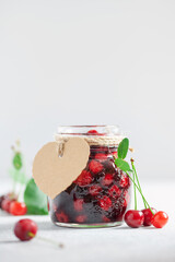 Homemade cherry jam in a jar and fresh berries on the table