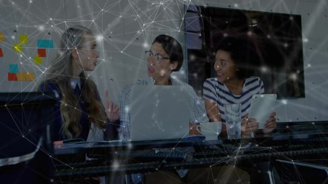 Colleagues discussing business strategy with laptop, tablet and animated technology network overlay
