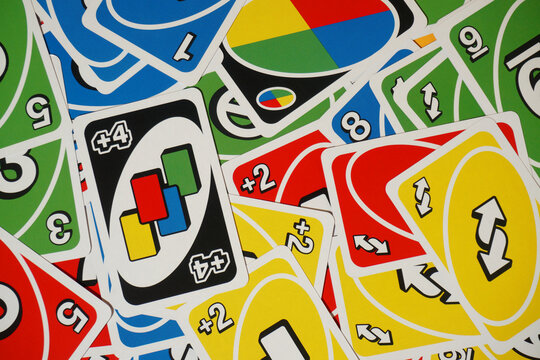 A stack of uno cards arranged in a mess on the table         