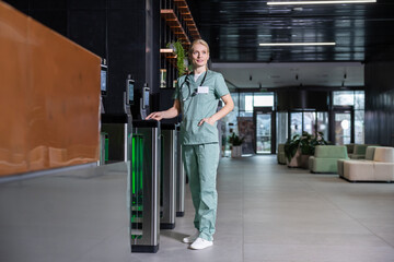 Fototapeta premium Female blonde doctor passing through security by using access card