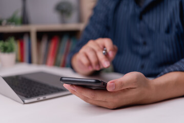 Businessman using smartphone for online communication and task planning at workspace. Digital business and modern technology.Remote office, mobile workflow.