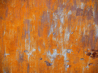 Rusty orange metal surface with weathered blue paint streaks