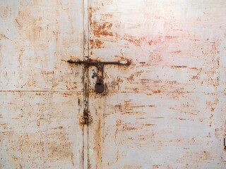Rusty metal door with lock and weathered texture