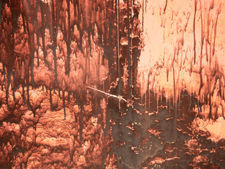 Abstract rusty metal surface with vertical drips of brown and orange hues