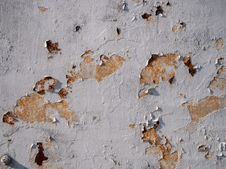 Peeling white paint on aged rusty metal surface with textured layers