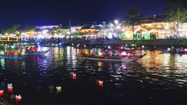 Nighttime boat journey highlighting hoi an's luminous charm, floating lanterns glimmering across thu bon river's surface during mesmerizing timelapse capture