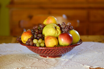 ceramic bowl with various ripe fruits at the table