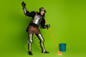 Obraz premium Knight in shining armor humorously mopping the floor against a vibrant green background