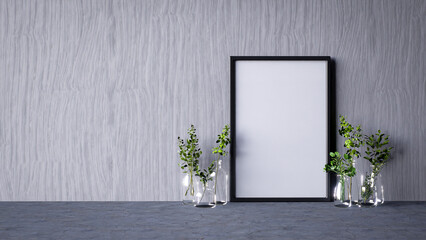 A minimalist setting featuring a blank frame against a textured wall, complemented by glass vases containing greenery.