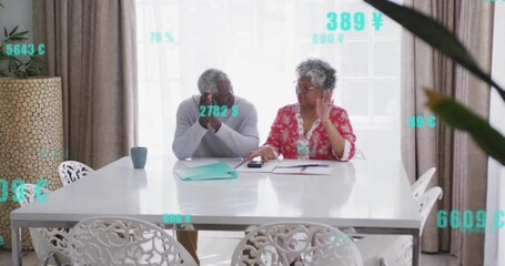 Senior woman and mature man analyzing budget showing floating currency overlays using calculator - Powered by Adobe