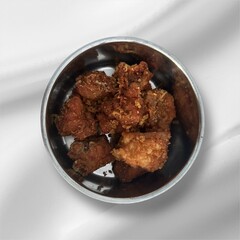 Chicken in a silver bowl isolated on white background. Chicken cut into small pieces and fried, ready to eat