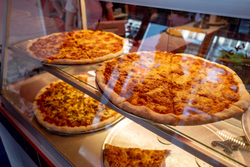 Pizzas being sold inside a glass sales counter in Thailand