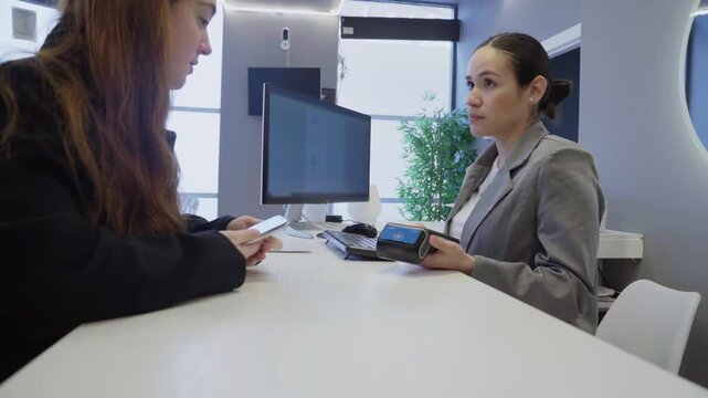 Patient paying dentist for treatment with contactless payment