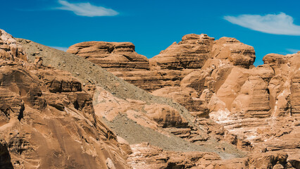 Fototapeta premium high rocky mountains in the desert against the blue sky and white clouds in Egypt Dahab South Sinai