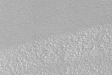 White paint stucco wall in the sun. Uneven grunge and rough concrete surface backdrop.