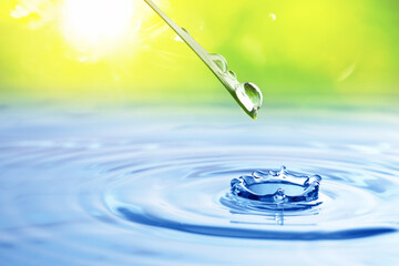 Drops falling from green leaf into water outdoors, closeup