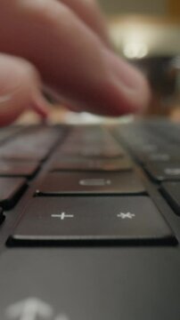 Close-up of mans fingers typing on laptop keyboard in modern caf&eacute;