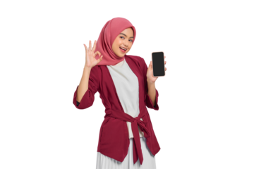 Happy young Asian Muslim woman in red hijab holding smartphone and making OK hand gesture isolated on transparent background