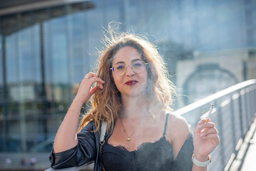 l&auml;chelnde junge Frau mit Zigarette in der Stadt