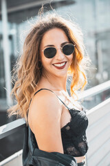 gl&uuml;ckliche junge Frau mit Sonnenbrille in der Stadt