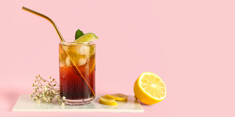 Glass of cold Long Island iced tea on pink background