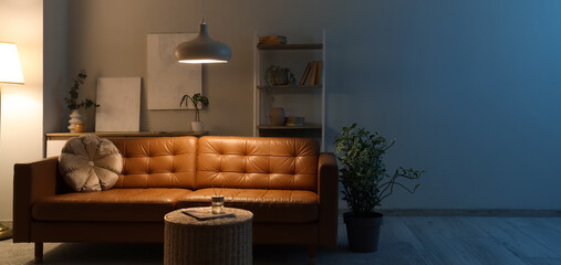 Interior of living room with sofa, shelf unit and table in evening. Banner for design