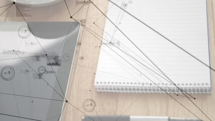 Gray tablet occupying left, notebook and pen lying right, network graphics floating above desk