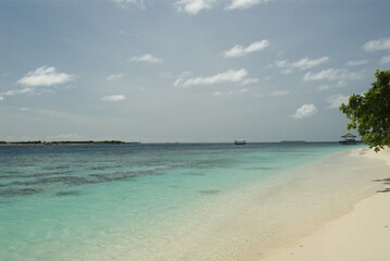 Tropical beach with clear blue water and white sand beachfront