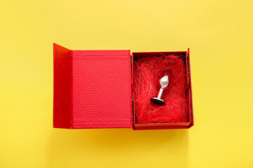 Anal plug in gift box on yellow background