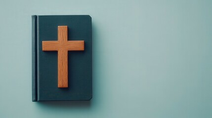 Obraz premium Close-up of a solemn prayer book with a wooden cross on a blue background, symbolizing faith and spirituality