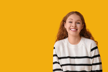 Portrait of nervous young woman smiling on yellow background