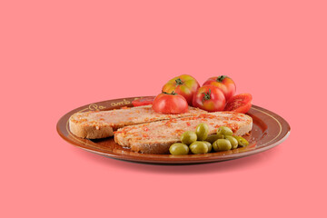 Pa amb tomAquet, the catalan tomato bread with sobrasada, served with olives and tomatoes on a brown plate