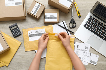 Female postal worker with package on table, top view