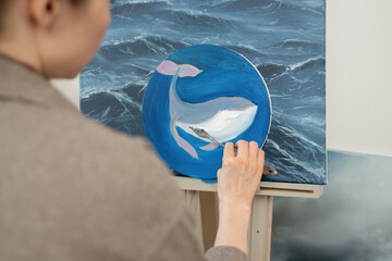 Painting of a whale on canvas inspired by ocean waves