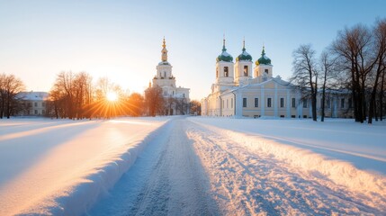 Winter sunrise over a historic church complex in a serene snowy landscape with trees lining the path during early morning