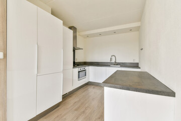 A sleek, modern kitchen featuring white cabinets and a minimalist design. The focus is on clean lines and functional space, ideal for contemporary living.