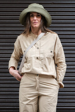 Woman in casual safari outfit in a dark background